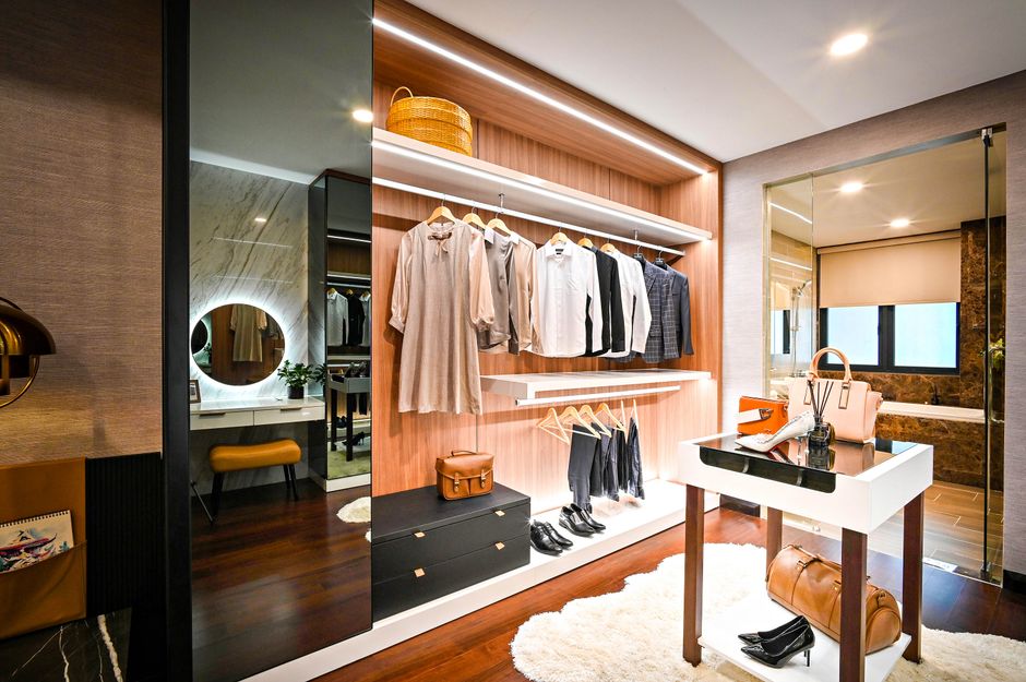 A beautifully designed modern walk-in closet with wooden shelving and ambient lighting